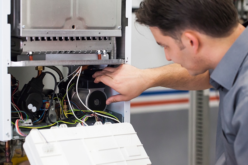 HVAC Technician examining heat pump.