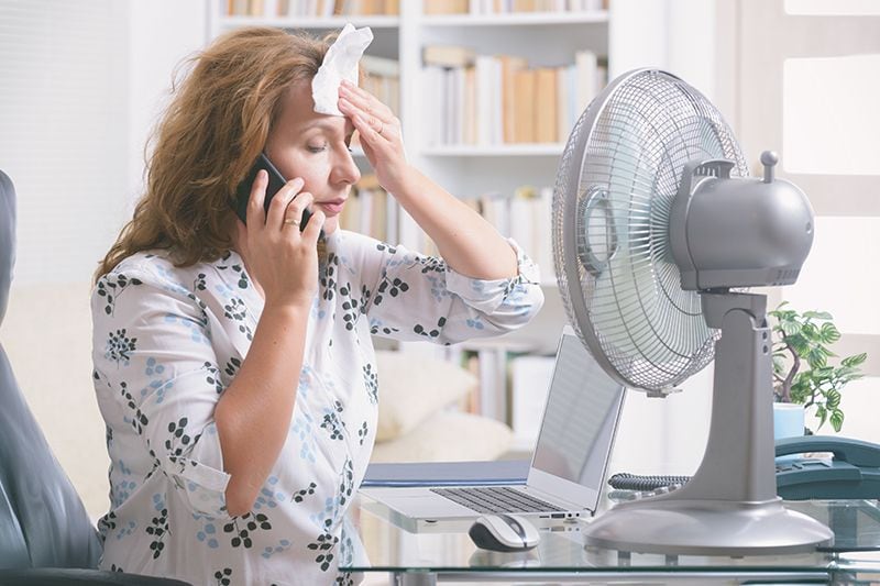 Image of person in front of fan. When Do I Replace My Air Conditioner?.